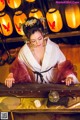 A woman in a white and red dress playing a musical instrument.