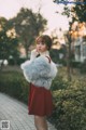 A woman in a red dress and a white fur coat.