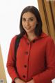 A woman in a red coat posing for a picture.