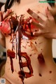 A woman with blood dripping down her breasts. 