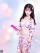 A woman in a pink kimono holding a cell phone.