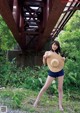 A woman in shorts and a straw hat posing for a picture.