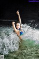 A woman in a blue bikini is in the water.